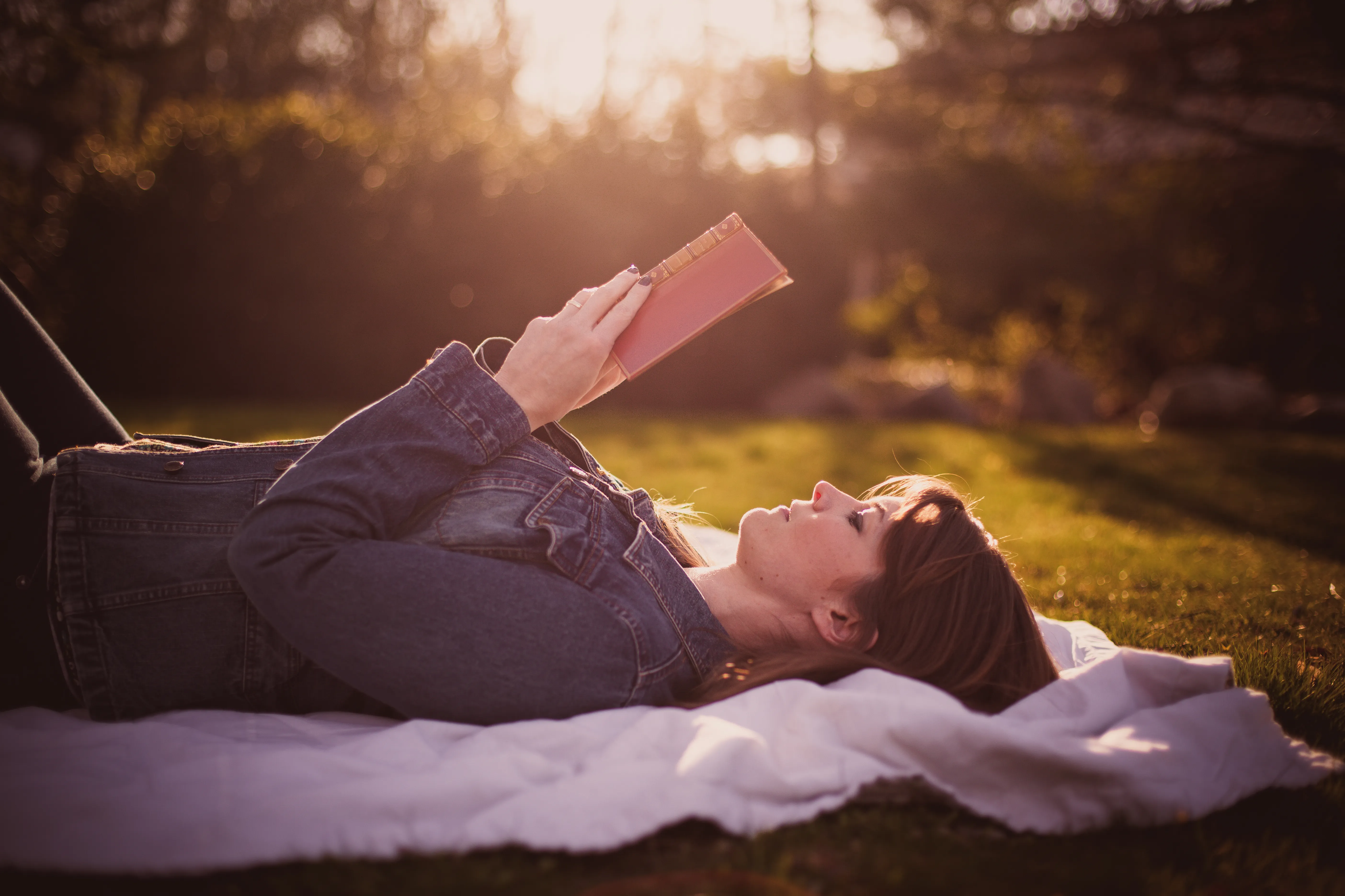 Jessie Wiegand lying in sunset reading a volume of Dorthy Parker's poetry. 